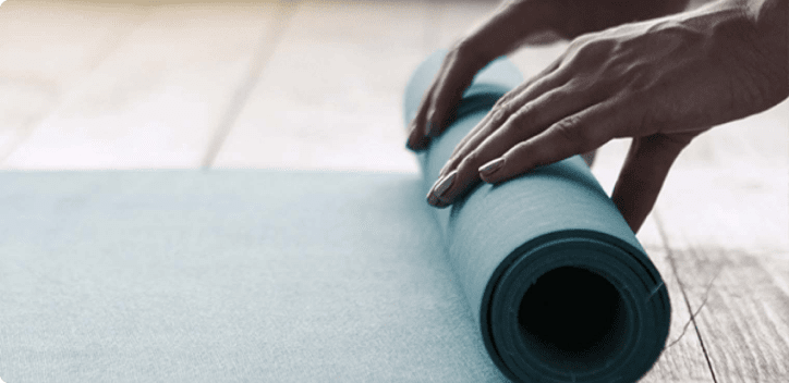 Hands rolling a yoga mat