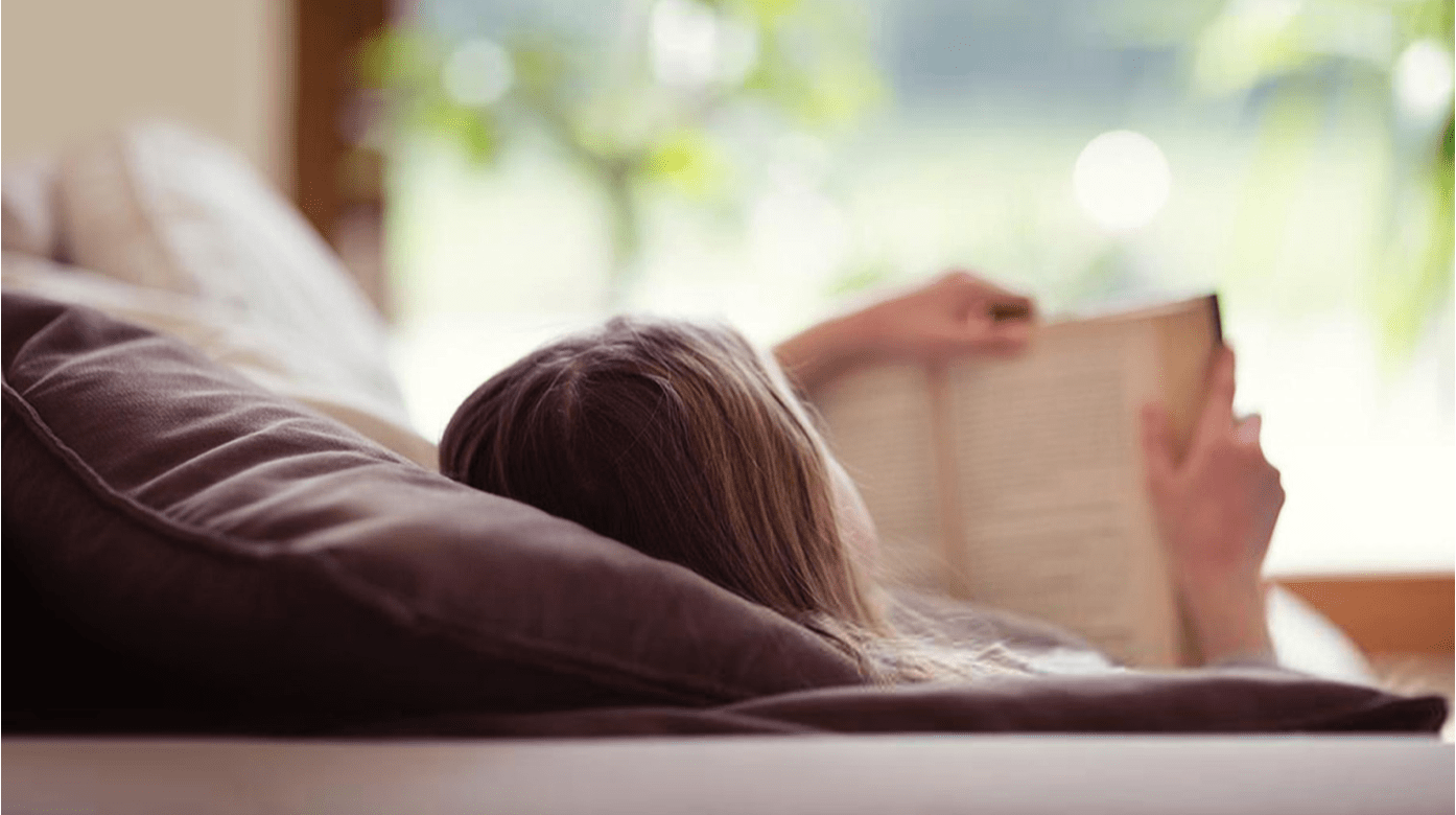 Woman reading a book and laying down