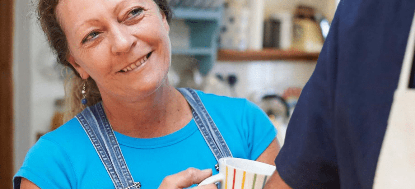 Woman smiling with cup in hand